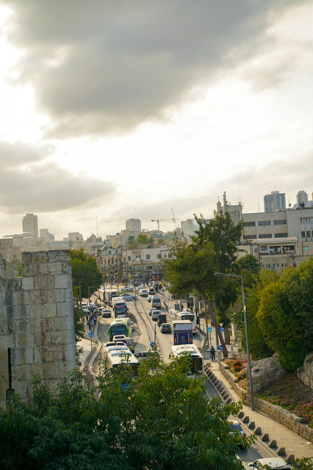 Busy street with traffic and buildings under cloudy sky
