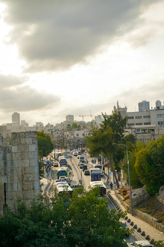 Busy street with traffic and buildings under cloudy sky